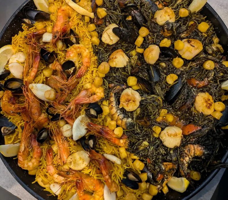 Paella Duo Safran, St Jacques, encre de Seiche, Riz Bomba, Poivrons, Artichaut, Sofrito, Gambas, Crevettes, Moules, Calamars, Seiche, tentacules